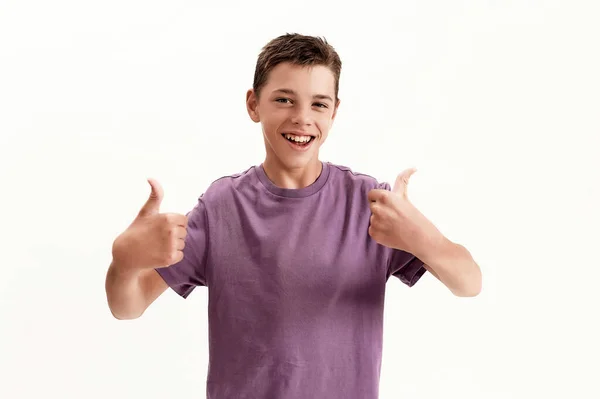 Happy adolescente deficiente menino com paralisia cerebral sorrindo para a câmera e mostrando os polegares para cima com as duas mãos, posando isolado sobre fundo branco — Fotografia de Stock