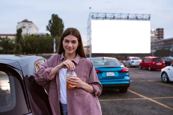Mladý kavkazský dívka stojící na auto kino parkoviště — Stock fotografie