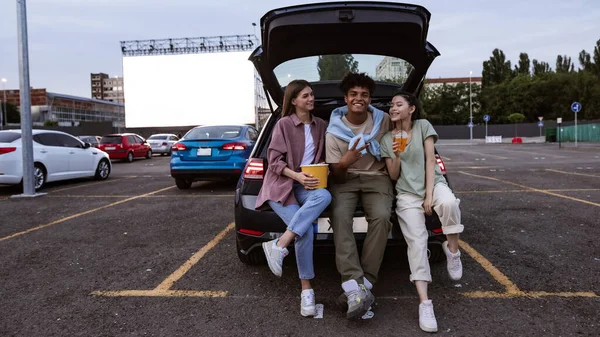 Jóvenes amigos alegres multirraciales en coche en el cine de automóviles —  Fotos de Stock