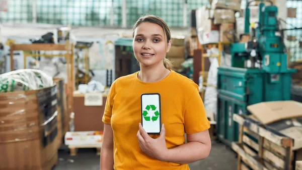 Young girl holding smartphone with recycling sign — Stock Photo, Image