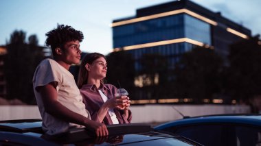 Çekici genç bir çiftin portresi, kız ve erkek birlikte vakit geçiriyorlar, sinemada film izlerken arabada oturuyorlar.