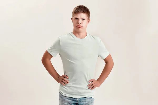 Vesel adolescent cu dizabilități băiat cu sindrom Down face fețe amuzante la aparat de fotografiat în timp ce pozează izolat pe fundal alb — Fotografie, imagine de stoc