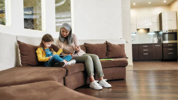 Klein meisje verwerpen om te lezen en spelen op tablet — Stockfoto