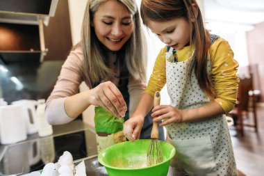 Mutlu torun çırparken un ekliyor çırpıyor.