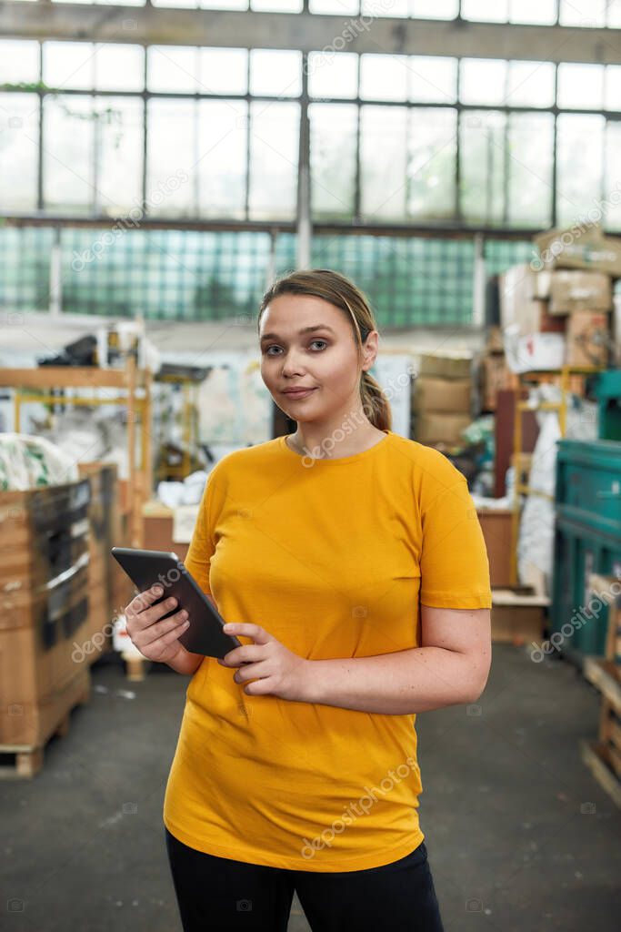 Girl standing with digital tablet on garbage disposal station