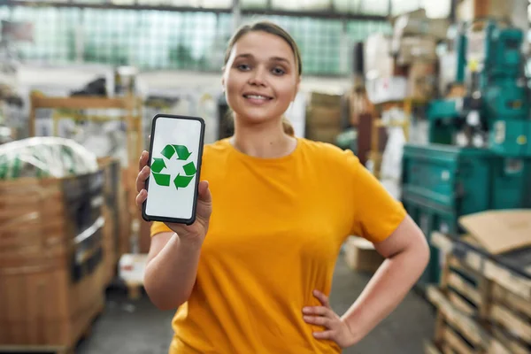 Smartphone screen showing recycling sign with green arrows — Stock Photo, Image