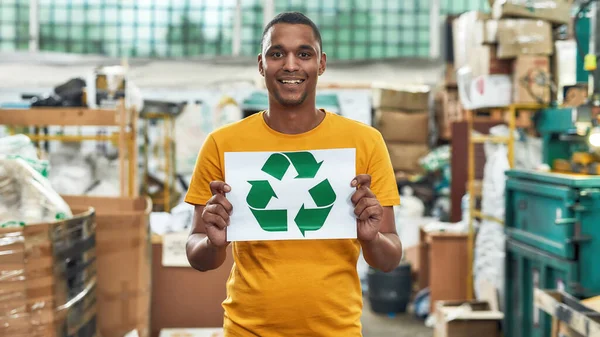 Recyclingschild in den Händen eines jungen Afrikaners — Stockfoto