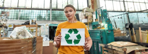 Menina segurando papel com flechas verdes sinal de reciclagem — Fotografia de Stock