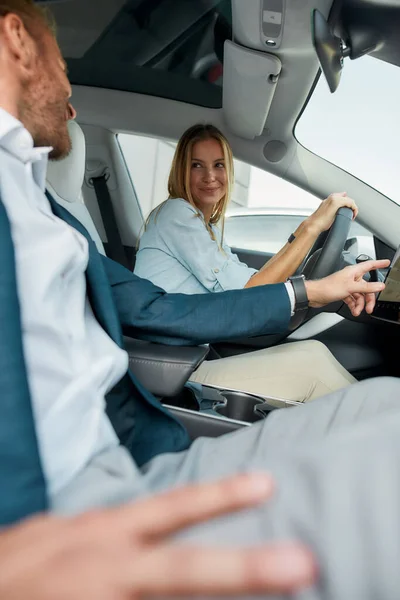 Jovem feliz olhando para o homem dentro do carro elétrico — Fotografia de Stock