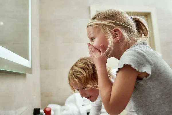 아침에 얼굴을 씻는 동안 거울을 보고 있는 귀여운두 어린 소년과 소녀 — 스톡 사진