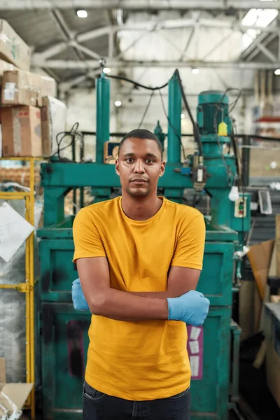アフリカ系アメリカ人男性が工業新聞の背景に立っている — ストック写真