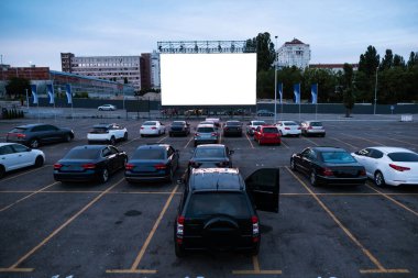 Otomatik sinema perdesinin önüne park edilmiş arabalar.