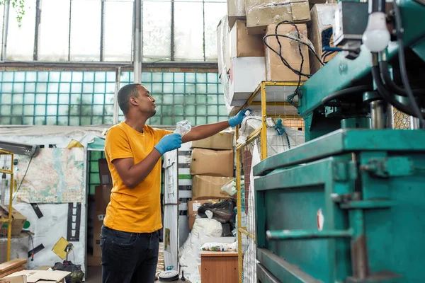 Jongeman zet plastic flessen in container — Stockfoto