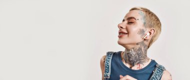 Müzik dinliyordum. Kot pantolon giymiş, kulaklığı kablosuz kulaklıklarıyla müzik dinleyen, gülümseyerek ve gülerek piercing takmış beyaz bir kız.