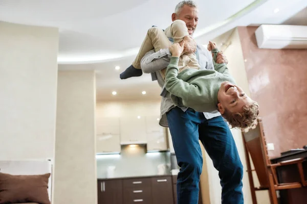 Il miglior nonno di sempre. Buon nonno e nipote bambino eccitato che giocano insieme, divertendosi in soggiorno a casa — Foto Stock
