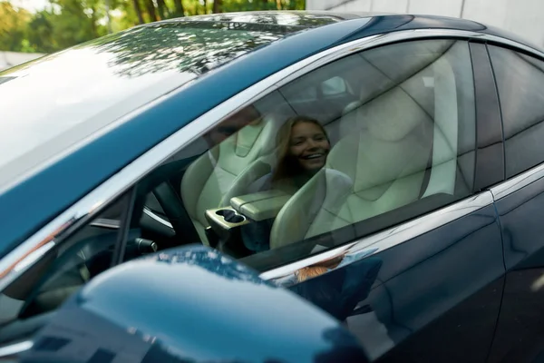 Sonriente joven pareja caucásica que refleja en la ventana del coche — Foto de Stock