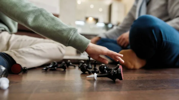 Spelet är slut. Schackfigurer på golvet, selektivt fokus, liten pojke som spelar schack med morfar hemma — Stockfoto