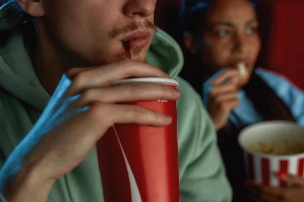 Close-up shot van jonge kerel drinken soda terwijl het kijken naar film in de bioscoop — Stockfoto