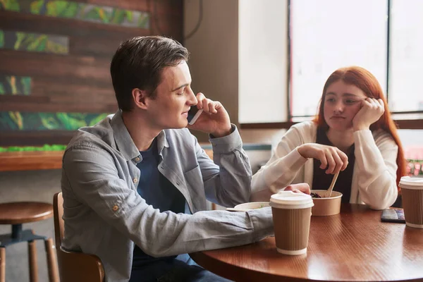 Δύο έφηβοι περνούν χρόνο μαζί, κάθονται σε ένα καφέ την ημέρα. Το κορίτσι δείχνει αναστατωμένο, τρώει το γεύμα της ενώ ο φίλος της την αγνοεί, μιλάει στο τηλέφωνο. — Φωτογραφία Αρχείου