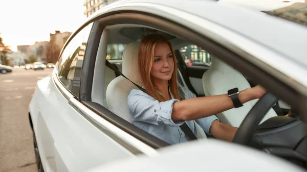 Jonge vrouw zit op de bestuurdersstoel in de auto — Stockfoto