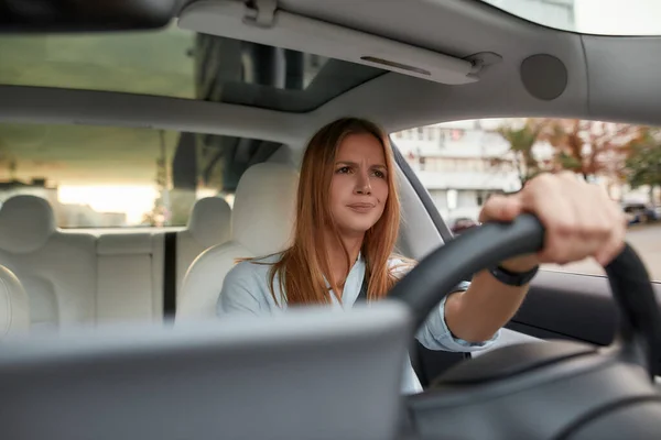 Jovem caucasiana irritada com as mãos no volante — Fotografia de Stock