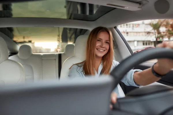 Sorrindo jovem caucasiana sentada no assento do motorista — Fotografia de Stock