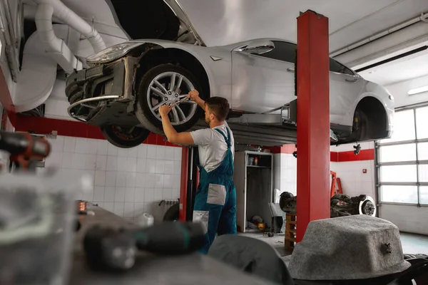 Trabajador atornillando rueda automática en la estación de servicio del coche — Foto de Stock