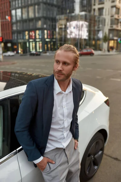 Knappe jonge blanke man in de buurt van een witte auto — Stockfoto