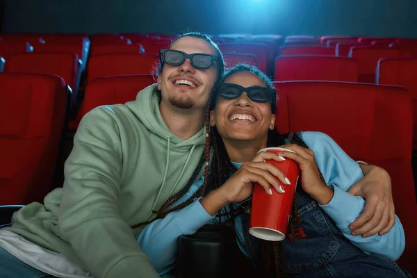 Porträt eines glücklichen jungen Paares mit 3D-Brille, das lächelnd eine Komödie im Kinosaal anschaut und Limo trinkt — Stockfoto