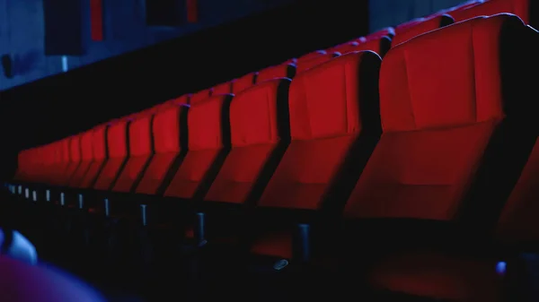 Close-up tiro de linha de assentos vermelhos no auditório de cinema vazio — Fotografia de Stock