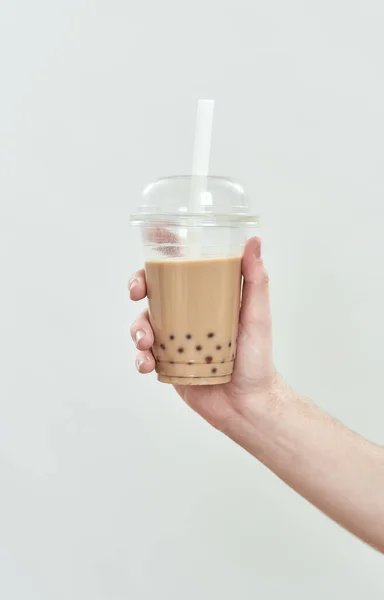 Kaffeegetränk in Plastikbecher auf hellem Hintergrund — Stockfoto