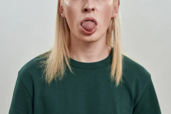 Retrato de un joven caucásico mostrando la lengua — Foto de Stock