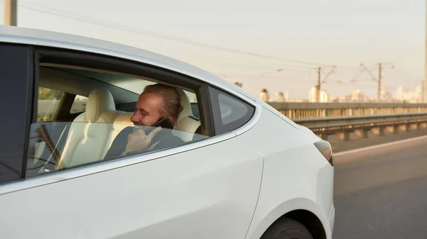 Glimlachende blanke zakenman aan de telefoon in de auto — Stockfoto