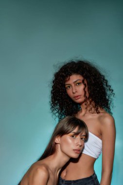 Kadın kafasını bir kadının göğsüne koyuyor.