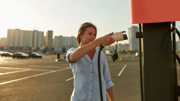 Glimlachen jong Kaukasisch meisje het nemen van auto lader — Stockfoto
