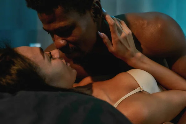Want you so hard. Young african man kissing and touching his girlfriend, half naked couple of lovers enjoying foreplay before making love in bedroom