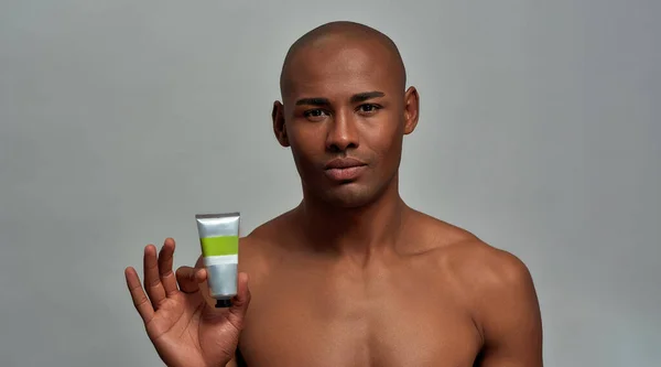 Skin care cream getting advertised by a handsome male — Stock Photo, Image