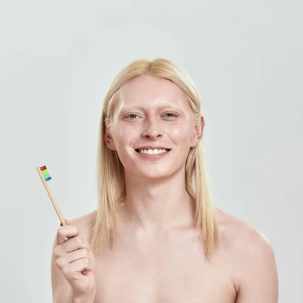 Портрет усміхненого чоловіка, який тримає зубну щітку в руці — стокове фото