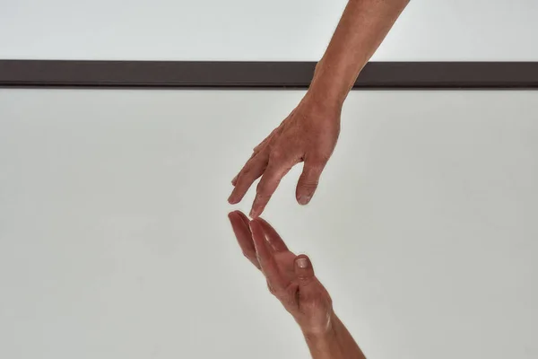 Nahaufnahme einer weiblichen Hand, die reflektierende Spiegeloberfläche auf dem Boden berührt, isoliert über hellem Hintergrund — Stockfoto