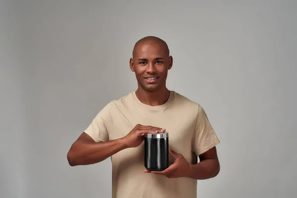 Sorrindo homem abrindo uma tampa de recipiente preto — Fotografia de Stock