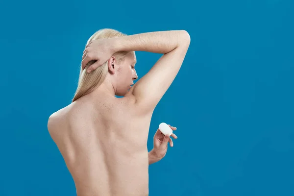 年轻的高加索人在腋窝上使用水晶除臭剂 — 图库照片