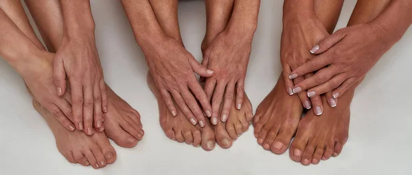 在白色背景下被隔离的成熟女性的女性脚上修整整齐的手与指甲的紧密相连 — 图库照片