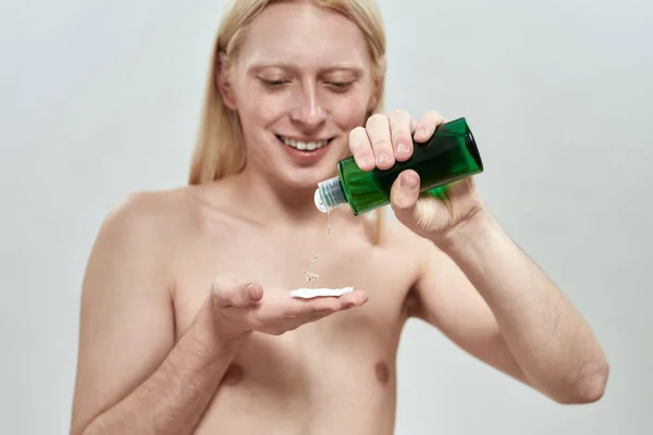 Selective focus on facial tonic in hands of young man — Stock Photo, Image