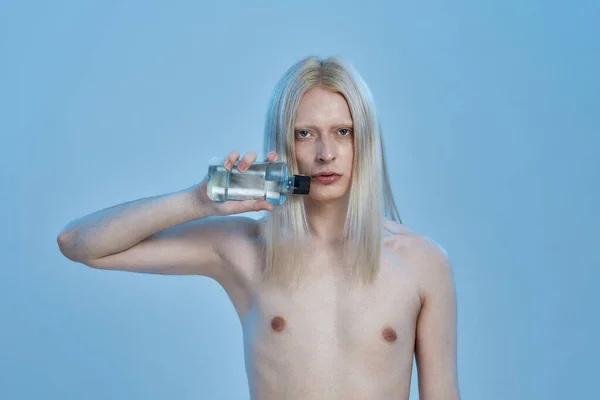 Молодий білий чоловік тримає пляшку з миттям рота — стокове фото