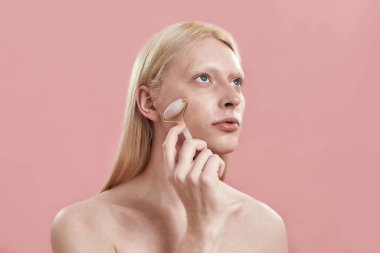 Kuvars silindirli, yüzü masaj yapan genç beyaz bir adam.