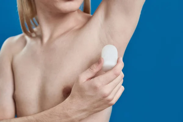 Молодий білий чоловік використовує кристалізований дезодорант на пахві — стокове фото