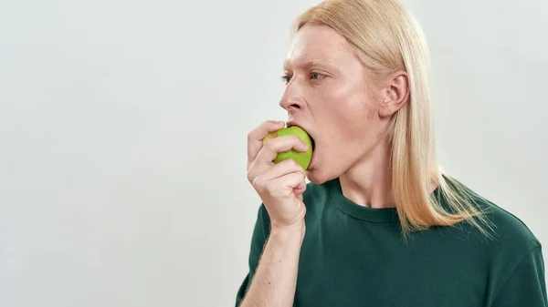 ハンサムな若いですcaucasian男biting緑ジューシーなリンゴ — ストック写真