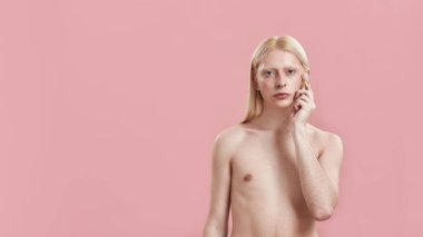 Genç beyaz adam yanağında kuvars silindiri kullanıyor.