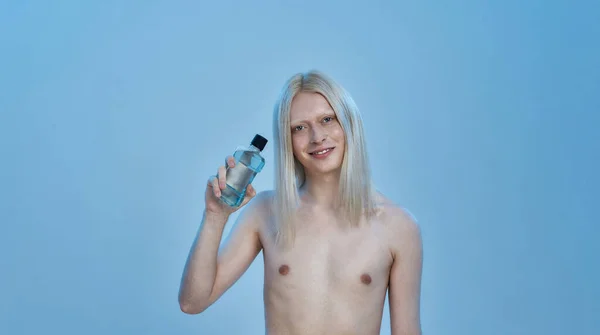 Smiling young caucasian boy holding mouthwash liquid — Stock Photo, Image