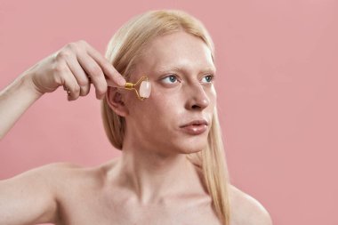 Genç adam göz masajı için kuvars silindiri kullanıyor.